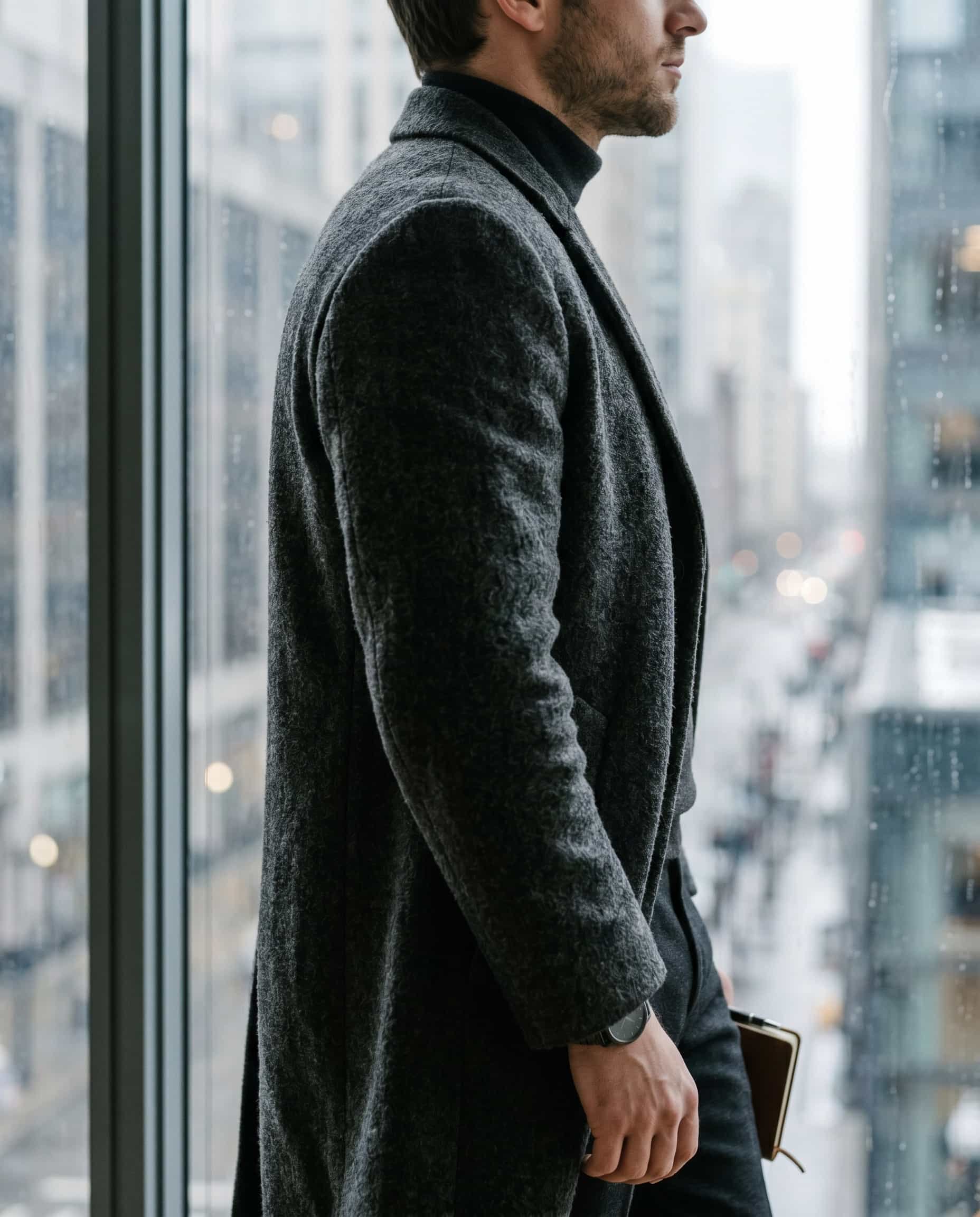 Drape and density define presence before any label Close-up of a high-quality wool overcoat showing drape and texture